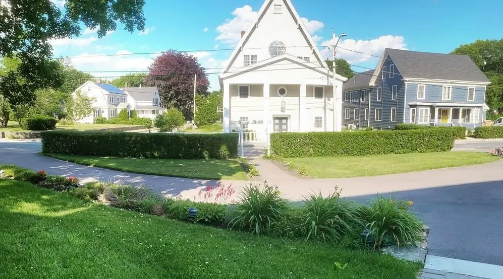 Long, squared-off hedges trimmed flat along a front lawn and walkway